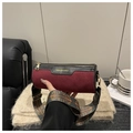 Detail of burgundy suede cylinder bag with a wide ethnic patterned strap and gold hardware - Red