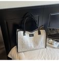 Bolso tote de lona blanca con bordado de colores y ribete negro sobre cama blanca - Blanco