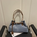 Borsa tote blu con stampa leopardata e tracolle marroni su una sedia in pelle nera - Blu