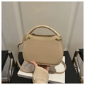 Detalle de bolso beige de media luna con herrajes dorados y piel sintética lisa elegante - Caqui
