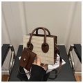 Dettaglio borsa tote in paglia intrecciata con finiture in pelle e piccolo borsellino - caffè