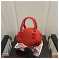 Detalle de bolso bowling de ante rojo con remaches plateados y ribetes de cuero liso - Rojo