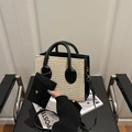 Straw and leather patchwork handbag with detachable mini pouch on a black chair - Black