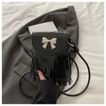 Chic black crossbody bag with metallic bow buckle and long tassels on blazer background - Black