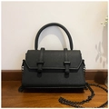 Detail einer schwarzen Handtasche aus Saffiano-Leder mit Rundgriff und dunkler Kette - Schwarz