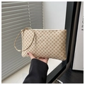 Close-up of beige envelope clutch with brown monogram patterns and a wristlet strap - Clover White