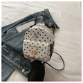 Detalle de mini mochila de lona blanca con lunares negros y hebilla de metal dorado - Negro