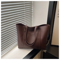 Detailed close-up of dark brown leather tote bag with exterior pocket and matte texture - Coffee