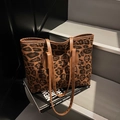 Grande borsa tote leopardata con manici in pelle marrone su una scala moderna - Marrone