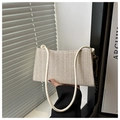 Bolso de hombro tejido beige con textura en V y correas largas en un ambiente de estilo - Blanco Roto