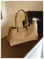 Brown faux suede tote bag with smooth handles shown in a cozy city lifestyle setting - Brown
