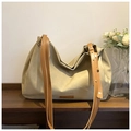Detail der khakifarbenen Hobo-Tasche mit großem Fassungsvermögen und Lederlogo auf Holzfläche - Khaki