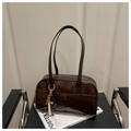 Detail of dark brown glossy shoulder bag with vintage wood bead charm on a leather chair - Coffee with Pendant