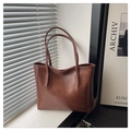 Detail of vintage brown PU leather tote bag with sturdy handles on a wooden table - Brown Without Pendant