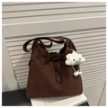 Detail of a brown drawstring tote bag with a white plush cloud charm and side brand label - With Pendant / Coffee