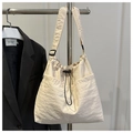 Detail of cream nylon tote bag featuring adjustable black straps and drawstring closure - No Pendant / Off White