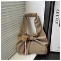 Detail of khaki bow tote bag with plush bear charm and pleated texture design - Khaki With Pendant