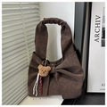 Detail of a dark brown hobo tote bag featuring a large bow and a plush bear charm - Coffee with Pendant