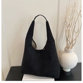 Minimalist black suede tote bag detail on a white book with elegant artistic vase decor - Black