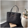 Dettaglio della borsa tote nera plissettata con fiocco dorato e motivi di fiocchi bianchi - Nero