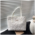Vista dettagliata della borsa tote plissettata bianca con fiocchi neri e fibbia dorata - Bianco