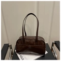 Detail shot of a dark brown glossy patent leather bowling bag on a chair with white books - Coffee Without Pendant