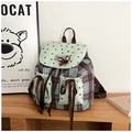 Dettaglio mini zaino a scacchi con stelle e fiocchi marroni su una scrivania in legno - Verde Menta