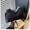 Detail of black plush teddy fabric texture with leather strap and golden buckle accents - Black