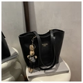 Detail einer schwarzen Leder-Shopper-Tasche mit einem süßen Hasenanhänger am Griff - Schwarz Mit Anhänger