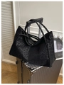Makro-Detail der schwarzen Totebag mit Leopardenmuster auf einem Koffer für Reisen - Schwarz
