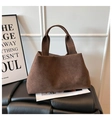 Dettaglio della consistenza opaca di una borsa tote in pelle scamosciata marrone scuro - caffè