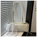 Detalle de un bolso baguette blanco crema con cintas de encaje y lazo ajustable - Blanco