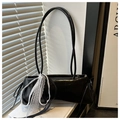 Detalle del bolso baguette de cuero PU negro con lazo de encaje blanco sobre unos libros - Negro