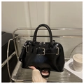 Detail of glossy black faux leather handbag with silver square buckle belt and dual zippers - Black
