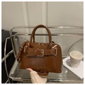 Detail view of brown glossy PU leather Boston bag with decorative buckle and silver zipper - Brown