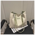 Detail van beige PU-leren shopper met lichtgroene handvatten en zilveren ketting - Groen zonder hanger