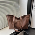 Retro brown leather tote bag with embossed logo and large capacity on shadow background - Brown