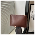 Detail of dark brown matte leather clutch bag featuring a gold zipper and wrist strap - Coffee