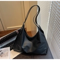 Minimalist black faux leather hobo shoulder bag next to laptop in a sunlit office - Black