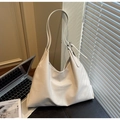 Close-up of beige faux leather tote with adjustable wide strap and silver metal buckle - White