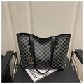 Dettaglio borsa shopper con monogramma retrò e pendente M dorato su sedia in pelle - Nero