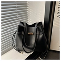 Detail of black bucket bag featuring golden twist lock and textured faux leather - Black