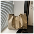 Detailansicht der beigen Shopper-Tasche mit goldener Kette und glänzender Lederoptik - Khaki