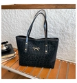 Detail of black leopard print tote bag featuring a decorative gold bow hardware pendant - Black