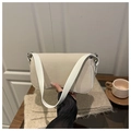 Detail view of a beige matte shoulder bag with a wide white strap in a lifestyle setting - White