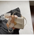 Detail van crème crossbodytas met gouden ringsluiting en zijden sjaal met hartjes - Wit