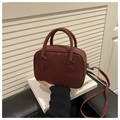 Détail du sac à main rouge foncé en similicuir avec poignées cylindriques et fermeture argentée - Rouge (Sans Charme)