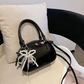 Bolso baguette negro brillante con lazo de perlas y encaje sobre una silla minimalista - Con Colgante / Negro