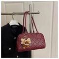 Detail van bordeauxrode gewatteerde schoudertas met pluche hanger en stikselpatroon - Rood