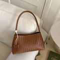 Bolso de hombro trenzado marrón caramelo estilo casual 2025 sobre sofá beige - Marrón